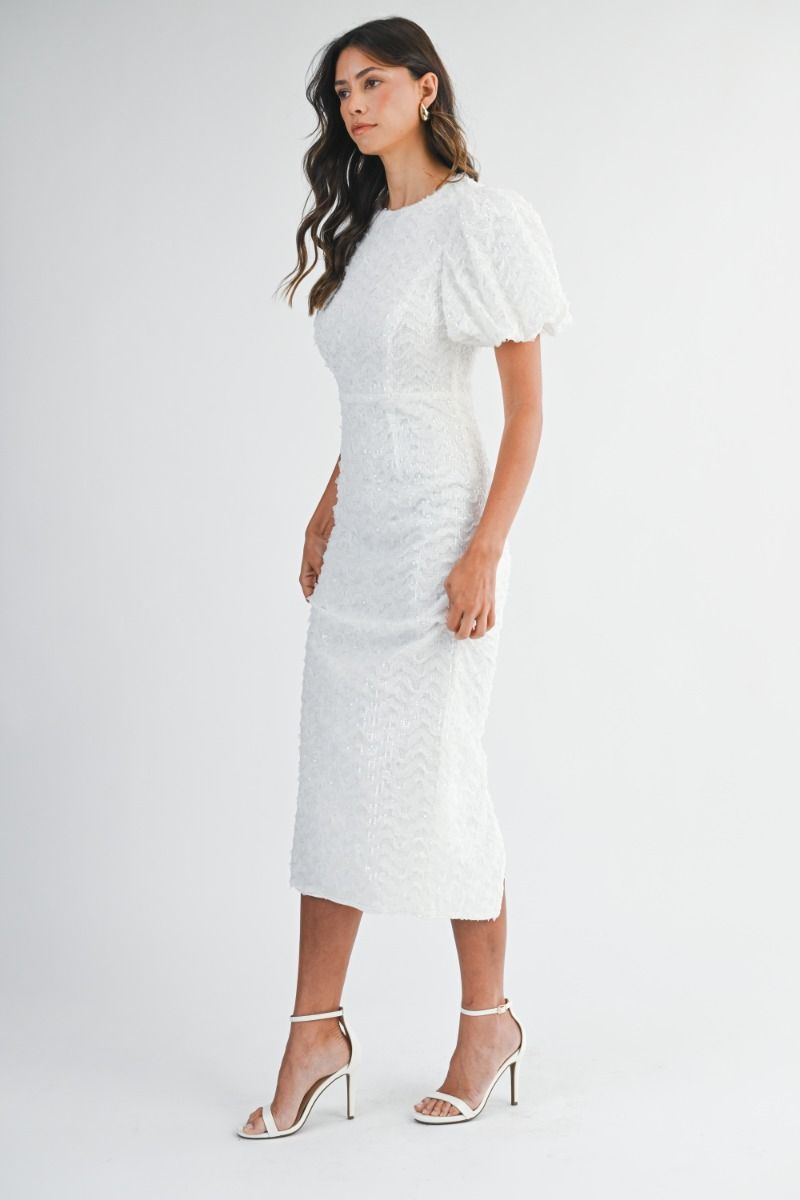 Sequin embellished mesh puff short sleeve fitted midi dress with back slit detail. Back keyhole button closure and invisible zipper