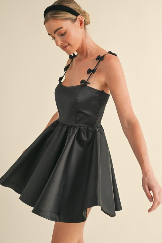 Adjustable spaghetti strap with bow applique detail fit and flare mini dress. Lining. Back invisible zipper